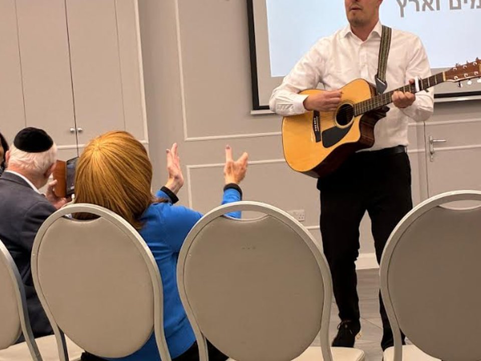 A Nigunim for Memory session, with a musician playing guitar